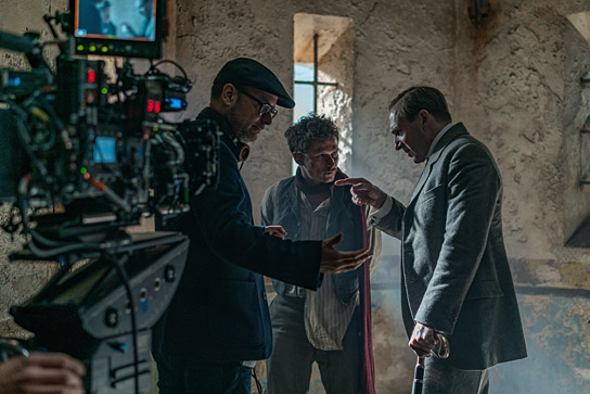 Matthew Vaughn (Regie), Joel Basman, Ralph Fiennes (v.l.n.r.) bei den Dreharbeiten zu "The King's Man - The Beginning" (2020); Quelle: Disney, DFF, © 2020 Twentieth Century Fox Film Corporation, Foto: Peter Mountain